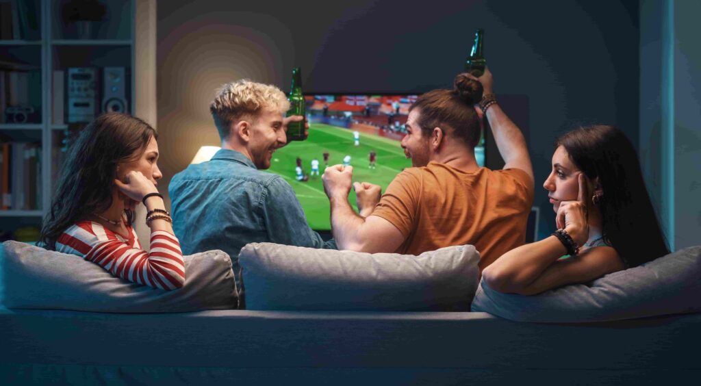 girls talking while men are watching soccer on tv
